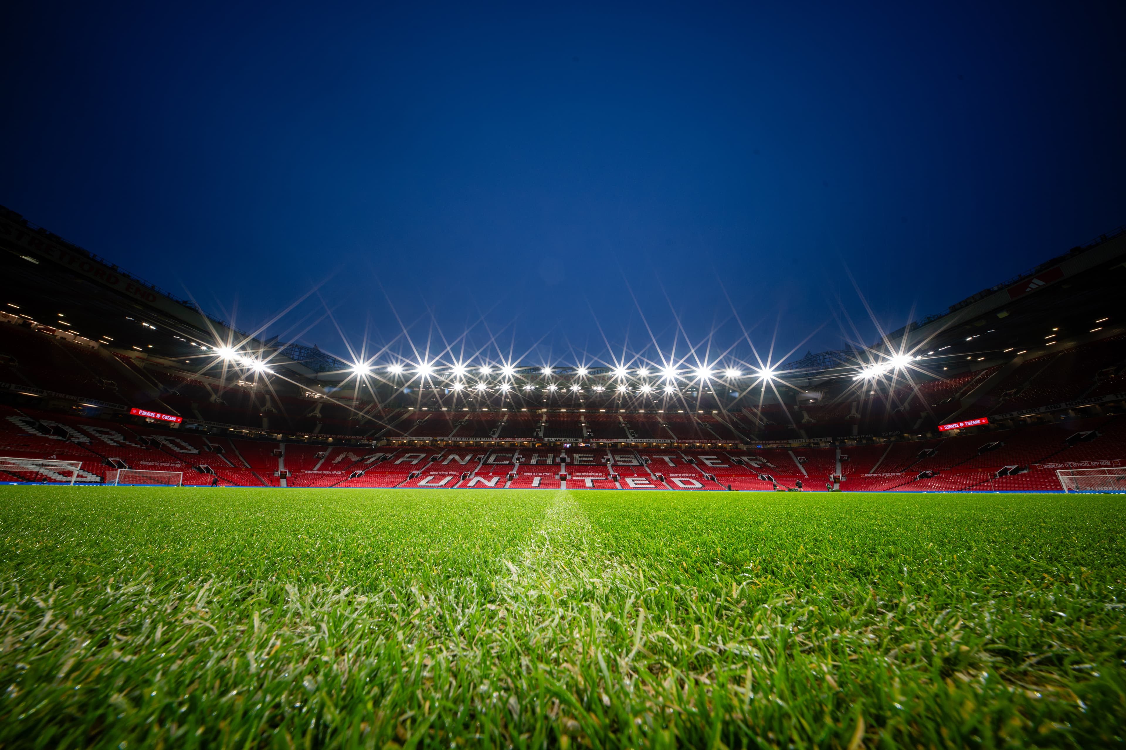 Old Trafford under floodlights at night ahead of a Manchester United home fixture